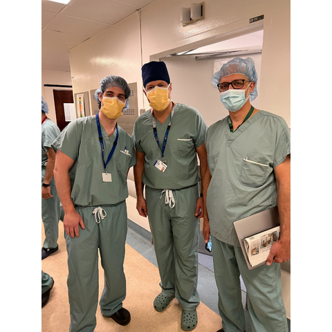 Group picture of three dentist standing in surgical clothing and masks