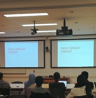 Students watch a presentation on breast cancer