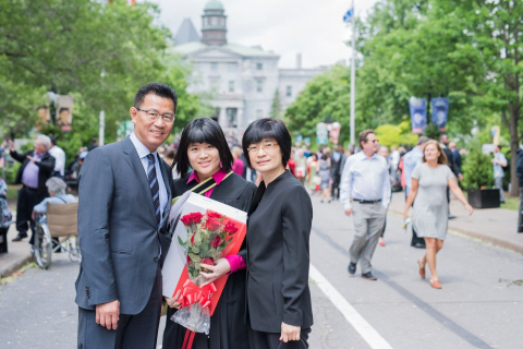 Image of graduating student with parents