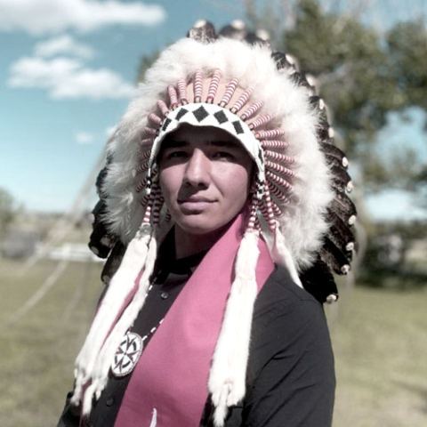 Portrait of Tomas Jirousek, ƻԺ student wearing traditional Indigenous headdress.